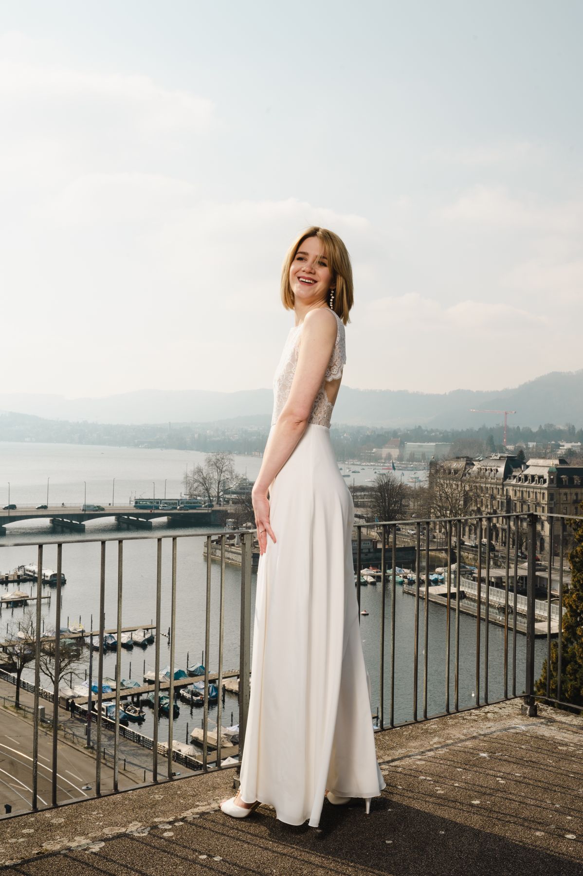 Langes schlichtes Hochzeitskleid nach Mass über den Dächern von Zürich